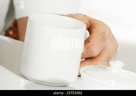 Nahaufnahme einer personÅ½s Hand, die einen Becher hält Stockfoto