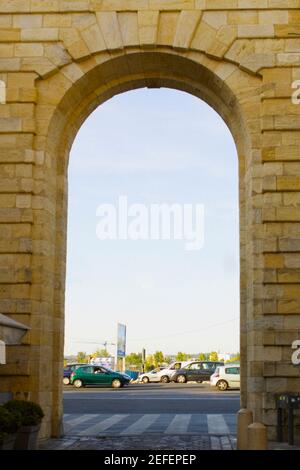 Verkehr auf der Straße durch einen Bogen gesehen, Porte de la Monnaie, Vieux Bordeaux, Bordeaux, Frankreich Stockfoto