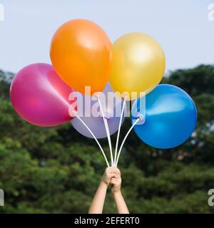 Nahaufnahme einer personÅ½s Hand, die Ballons hält Stockfoto