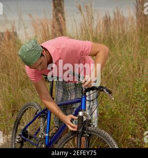 Nahaufnahme eines jungen Mannes, der sein Fahrrad repariert Stockfoto