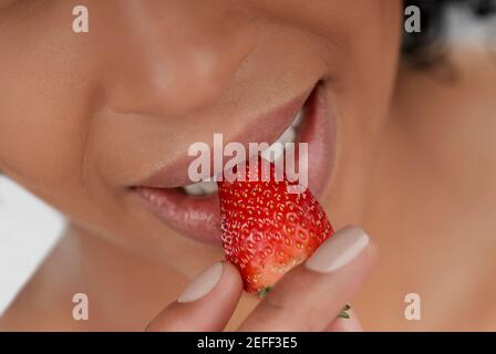 Nahaufnahme einer jungen Frau eine Erdbeere essen Stockfoto