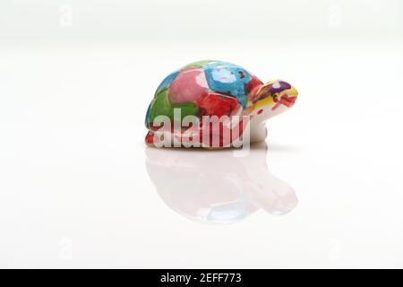 Ein kleines Kinder Lockdown Schule Kunstprojekt einer handbemalten china Schildkröte mit Kopieplatz auf weißem Hintergrund. Stockfoto