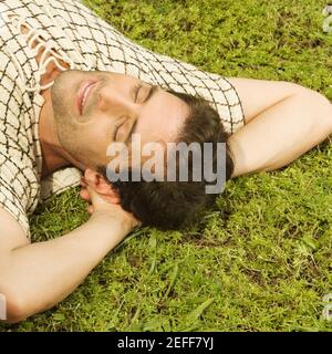 Man hatte einen Ausblick auf einen Mann mit mittlerem Erwachsenen, der schlief Das Gras Stockfoto