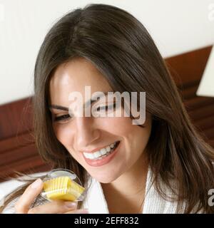 Nahaufnahme einer jungen Frau, die einen Cupcake hält und lächelt Stockfoto