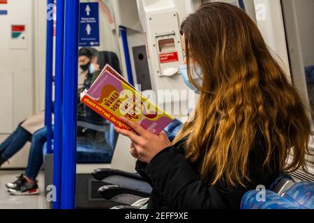 London, Großbritannien. Februar 2021, 17th. Eine Frau liest Women Don't Owe You Pretty: Das Debüt-Buch aus Florenz gegeben - der Untergrund ist manchmal ruhig während der nationalen Lockdown, Stay At Home, Anweisungen. Die meisten Reisenden tragen Masken, da sie bereits obligatorisch sind. Kredit: Guy Bell/Alamy Live Nachrichten Stockfoto