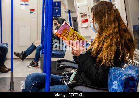 London, Großbritannien. Februar 2021, 17th. Eine Frau liest Women Don't Owe You Pretty: Das Debüt-Buch aus Florenz gegeben - der Untergrund ist manchmal ruhig während der nationalen Lockdown, Stay At Home, Anweisungen. Die meisten Reisenden tragen Masken, da sie bereits obligatorisch sind. Kredit: Guy Bell/Alamy Live Nachrichten Stockfoto