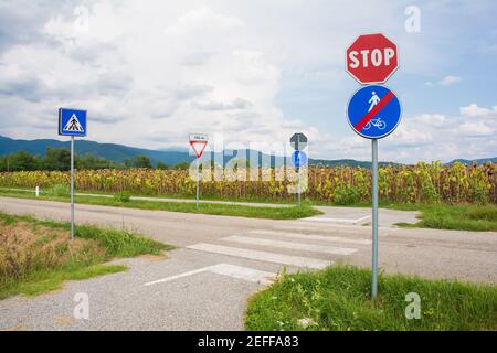 Eine Fußgängerüberfahrt, bei der ein Radweg eine Landstraße in Friaul-Julisch Venetien im Nordosten Italiens kreuzt. Ein Schild weist darauf hin, dass Fahrer nachgeben müssen Stockfoto