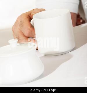 Nahaufnahme einer personÅ½s Hand, die einen Becher hält Stockfoto