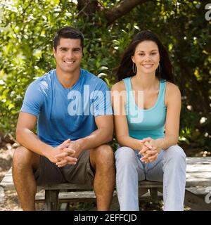 Porträt einer jungen Frau und eines mittleren erwachsenen Mannes Zusammen sitzen Stockfoto