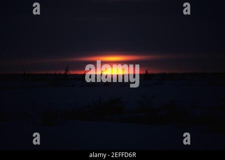 Sonnenuntergang über einer gefrorenen Landschaft, Churchill, Manitoba, Kanada Stockfoto