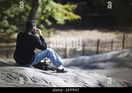 Rückansicht eines Mannes, der auf einem Mobiltelefon spricht Stockfoto