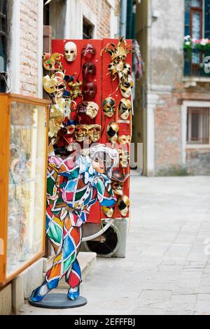 Verschiedene Arten von Masken hängen an der Tür eines Speichern Stockfoto