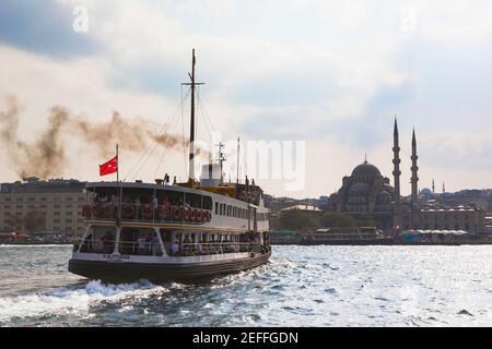 Istanbul, Türkei. Fähre dampft in Eminönü Hafen. Yeni Cami, oder die Neue Moschee im Hintergrund. Stockfoto