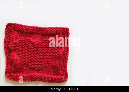 Rot gestricktes Quadrat mit Herzmotiv Stockfoto