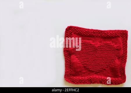 Rot gestricktes Quadrat mit Herzmotiv Stockfoto