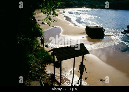 Silhouette von zwei Männern auf einem abgelegenen und ruhigen Strand gesehen, St. Lucia Stockfoto