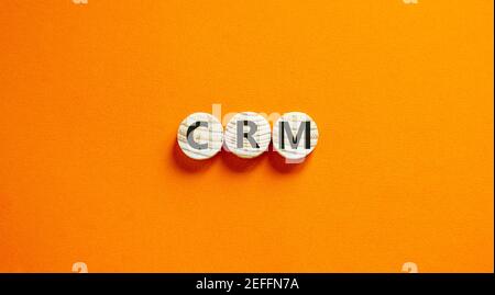 CRM, Symbol für Customer Relationship Management. Wörter „CRM, Customer Relationship Management“ auf Kreisen auf einem schönen orangefarbenen Hintergrund. Business und Stockfoto