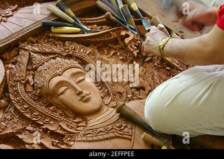 Nahaufnahme einer personÅ½s Hände, die eine Statue von Buddha auf Holz geschnitzt hat, Chiang Rai, Thailand Stockfoto