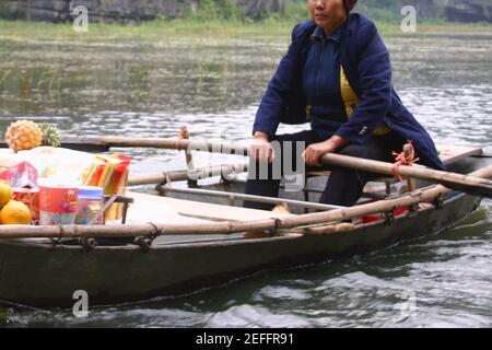 Weibliche Verkäuferin in einem Boot auf einem schwimmenden Markt, Dong Hoi, Vietnam Stockfoto
