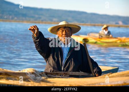 Fischer auf einem Boot und zeigt einen Fisch, Janitzio Insel, See Patzcuaro, Patzcuaro, Michoacan Staat, Mexiko Stockfoto