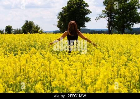 Rückansicht einer jungen Frau, die in einem Feld, Tschechische Republik Stockfoto