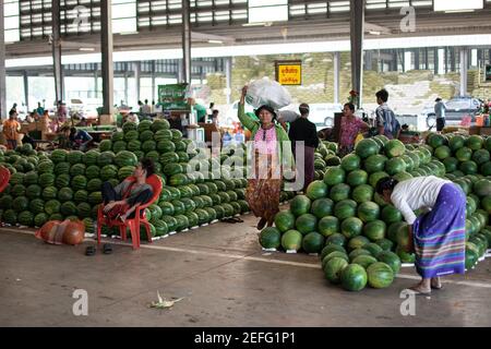 YANGON, MYANMAR - DEZEMBER 31 2019: Riesige Stapel frischer Wassermelonen auf einem lokalen Straßenmarkt in Myanmar Stockfoto