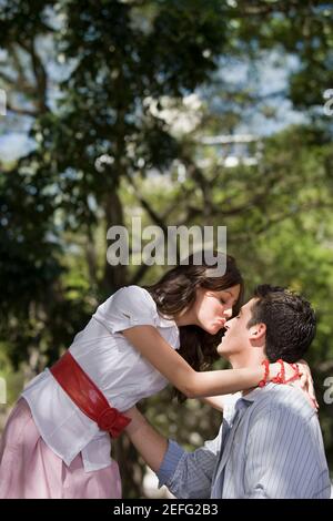 Seitenansicht eines jungen Paares in einem Park romancing Stockfoto