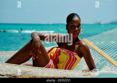 Vorderansicht einer Frau, die sich in einer Hängematte im Crystal Palace Hotel, Nassau, Bahamas, entspannt Stockfoto