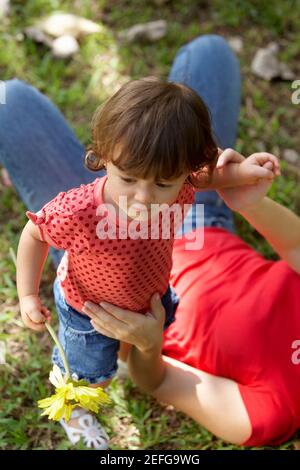 Erhöhte Ansicht einer jungen Frau auf dem Rasen liegen und hält ihre Tochter Stockfoto