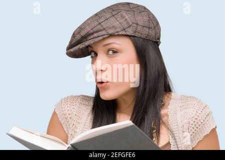 Porträt einer jungen Frau mit einem Buch vor ihr Pfeifen Stockfoto