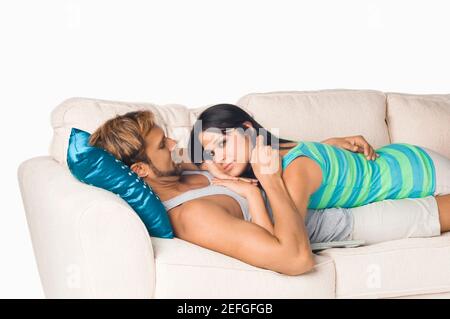 Seitenansicht von ein paar romancing auf einer couch Stockfoto