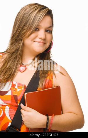 Porträt einer jungen Frau hält ein Tagebuch und lächelnd Stockfoto