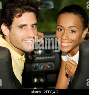 Porträt einer jungen Frau und eines mittleren erwachsenen Mannes Sitzen in einem Auto Stockfoto