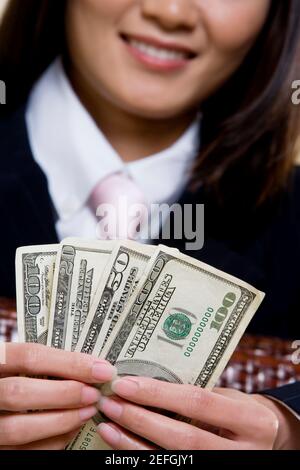 Nahaufnahme einer Geschäftsfrau, die hundert Dollarscheine hält Stockfoto