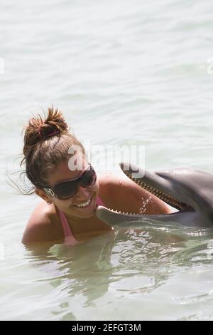 Teenager-Mädchen spielt mit einem Delphin, Roatan, Bay Islands, Honduras Stockfoto