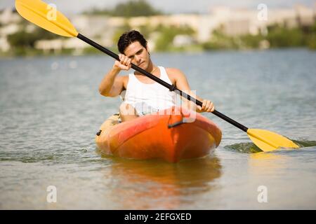 Junger Mann mit Kajak in einem See Stockfoto