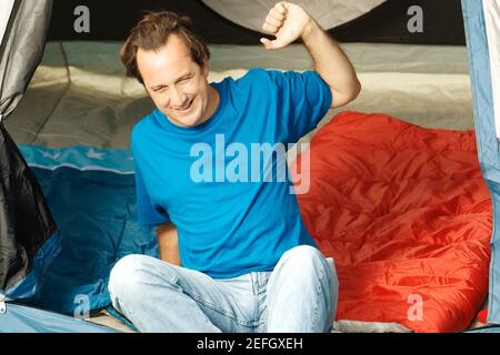Reifer Mann sitzt in einem Zelt Stretching Stockfoto