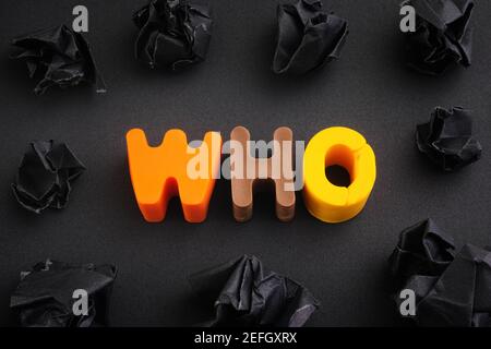 Das Wort, das aus Fimo Buchstaben mit einigen schwarzen zerknitterten Papierkugeln um sie gemacht. Nahaufnahme. Stockfoto