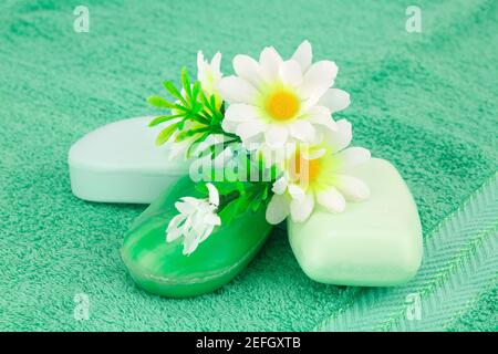 Bunte Seifen und Blumen auf grünem Tuch. Stockfoto