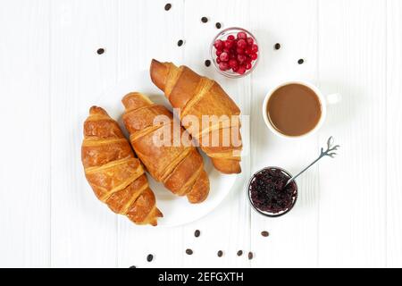 Leckere Croissants mit Beeren, Marmelade und Tasse Kaffee Draufsicht. Konzept für das Frühstück am Morgen Stockfoto