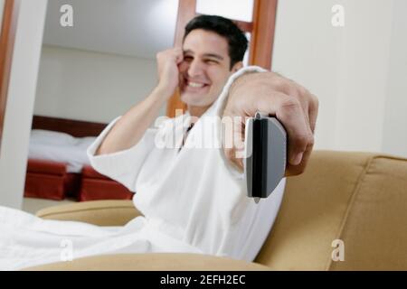 Porträt eines jungen Mannes mit einer Fernbedienung und Lächelnd Stockfoto