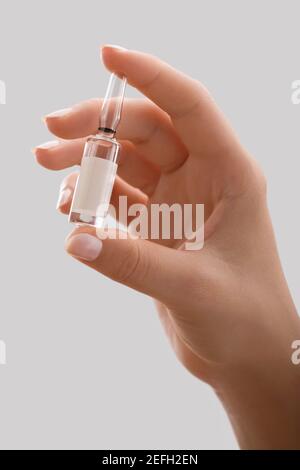 Nahaufnahme einer personÅ½s Hand, die ein Fläschchen hält Stockfoto