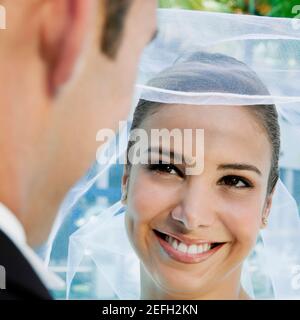 Nahaufnahme eines Bräutigams, der seinen brideÅ½s-Schleier hebt Stockfoto