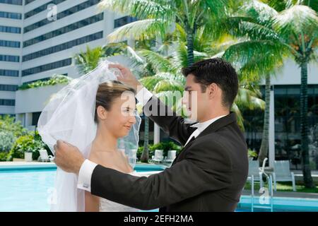 Seitenprofil eines Bräutigams, der seinen brideÅ½s Schleier hebt Stockfoto