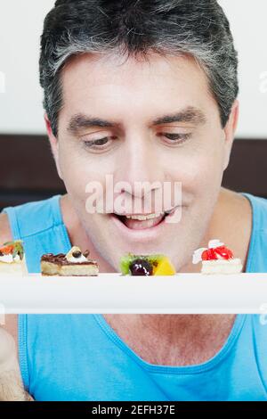 Reifer Mann, der Gebäck ansieht Stockfoto