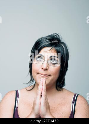 Nahaufnahme einer mittleren erwachsenen Frau in einer Gebetshaltung Stockfoto