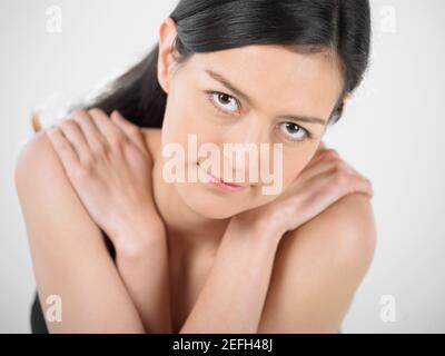 Porträt einer jungen Frau, die sich umarmt Stockfoto