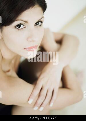 Porträt einer jungen Frau auf dem Boden sitzend Stockfoto