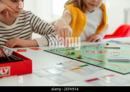 KIEL, DEUTSCHLAND - 14. Februar 2021: Fröhliche Kinder, die gemeinsam mit ihren Eltern Spaß am Brettspiel haben Stockfoto