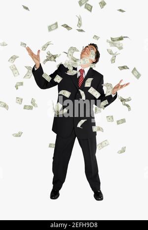 Amerikanische Dollarscheine, die auf einen Geschäftsmann herabregnen Stockfoto
